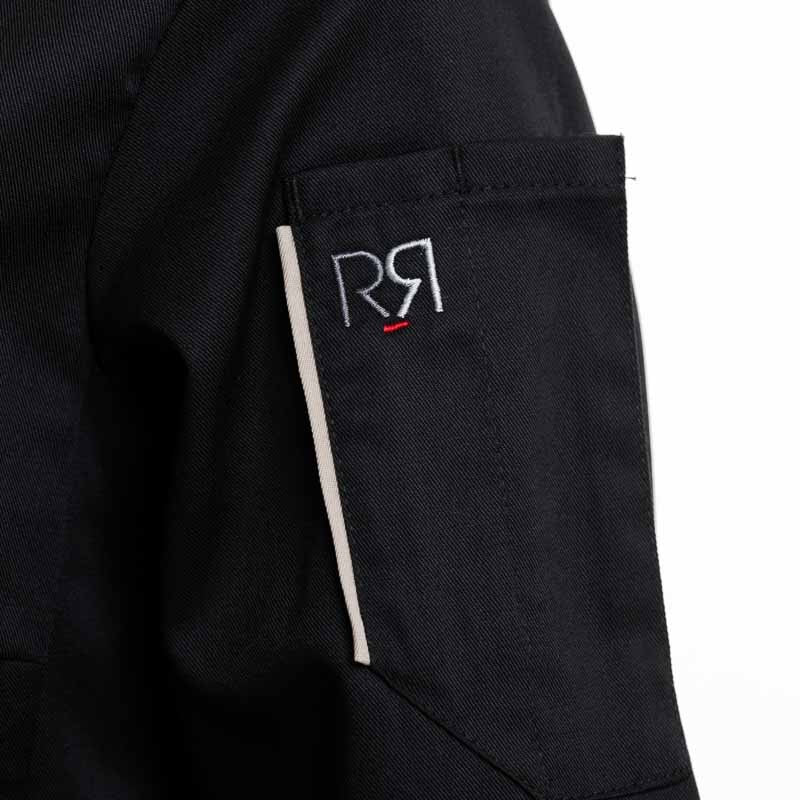 Détail de la veste de cuisine Unera à manches longues noire pour femme avec le parement sur la poche stylo