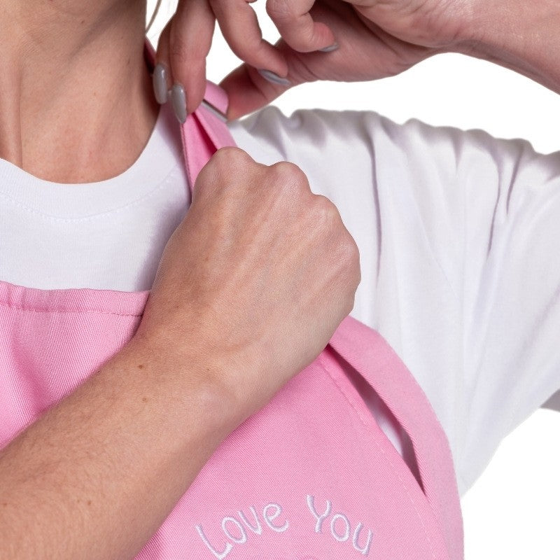 Zoom sur le tablier à bavette rose et sa broderie