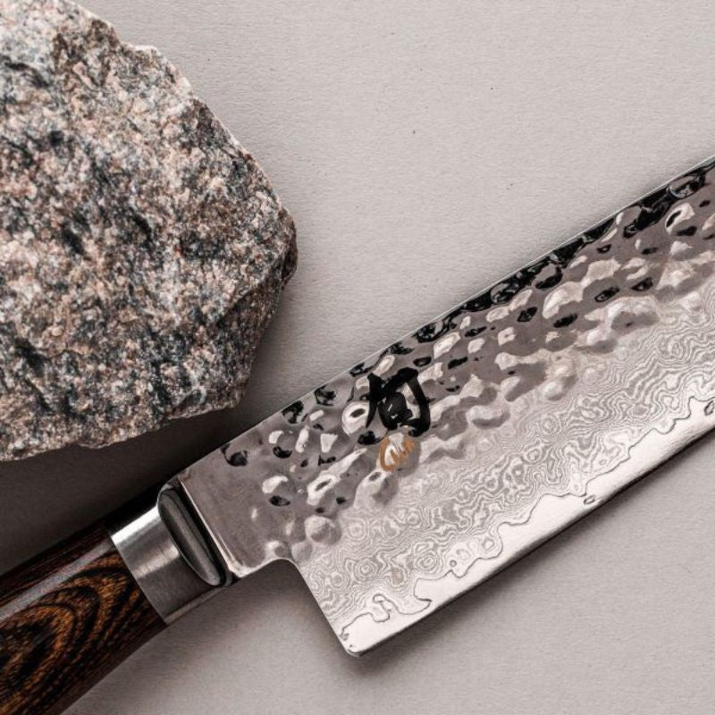 Détail de la lame martelée lisse du couteau santoku de chef japonais 18 cm Shun premier de la marque Kai